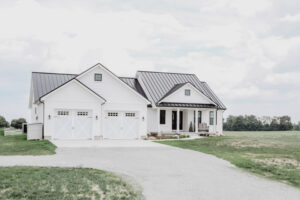 White modern farmhouse style custom home with standing seam metal roof built in Ohio
